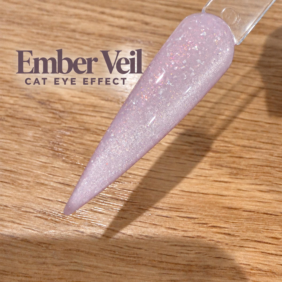 A close-up image of a purple glitter nail polish on a wooden surface, with the text "Ember Veil CAT EYE EFFECT" displayed above it.
