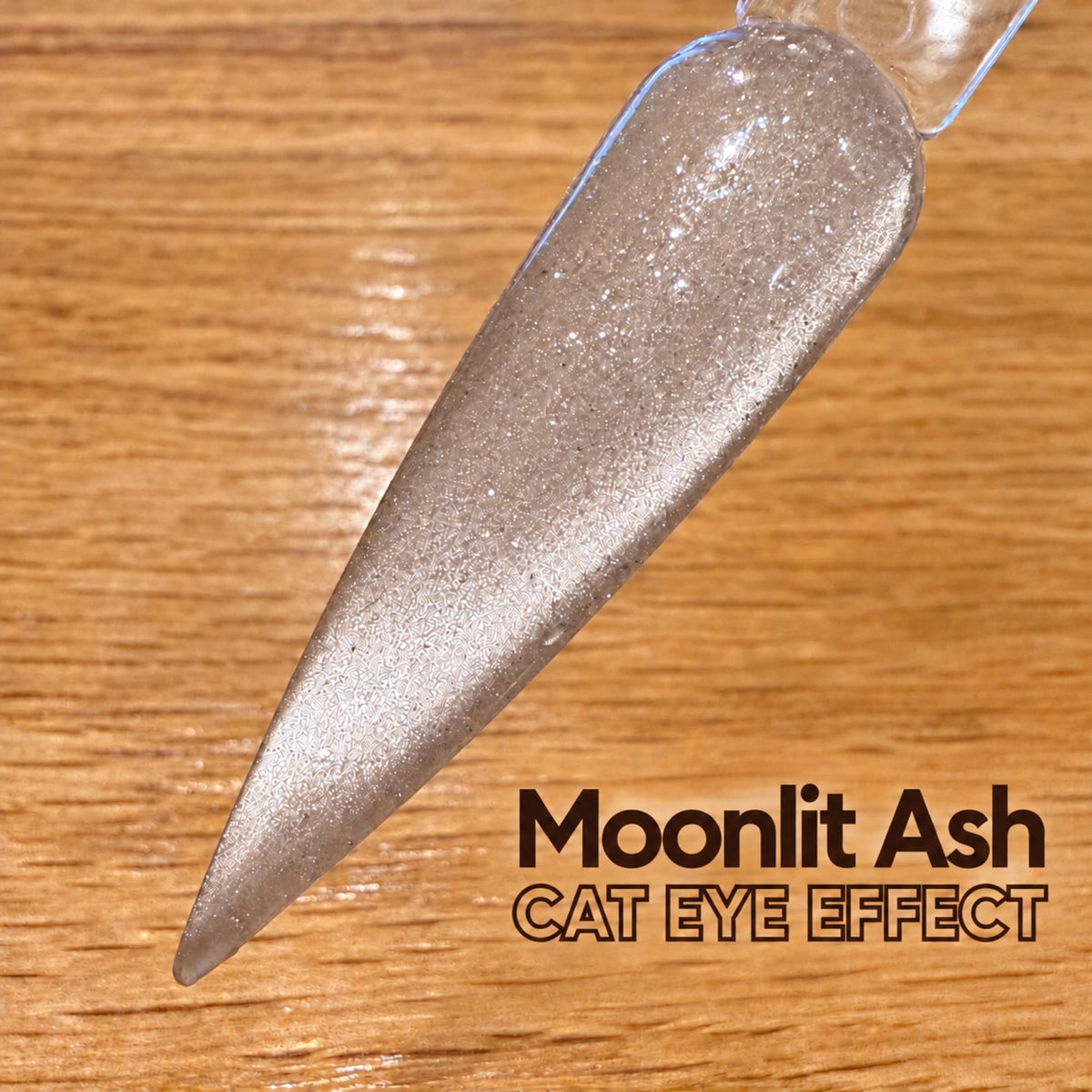 A close-up view of a nail polish bottle with a metallic silver glittery texture, placed on a wooden surface.