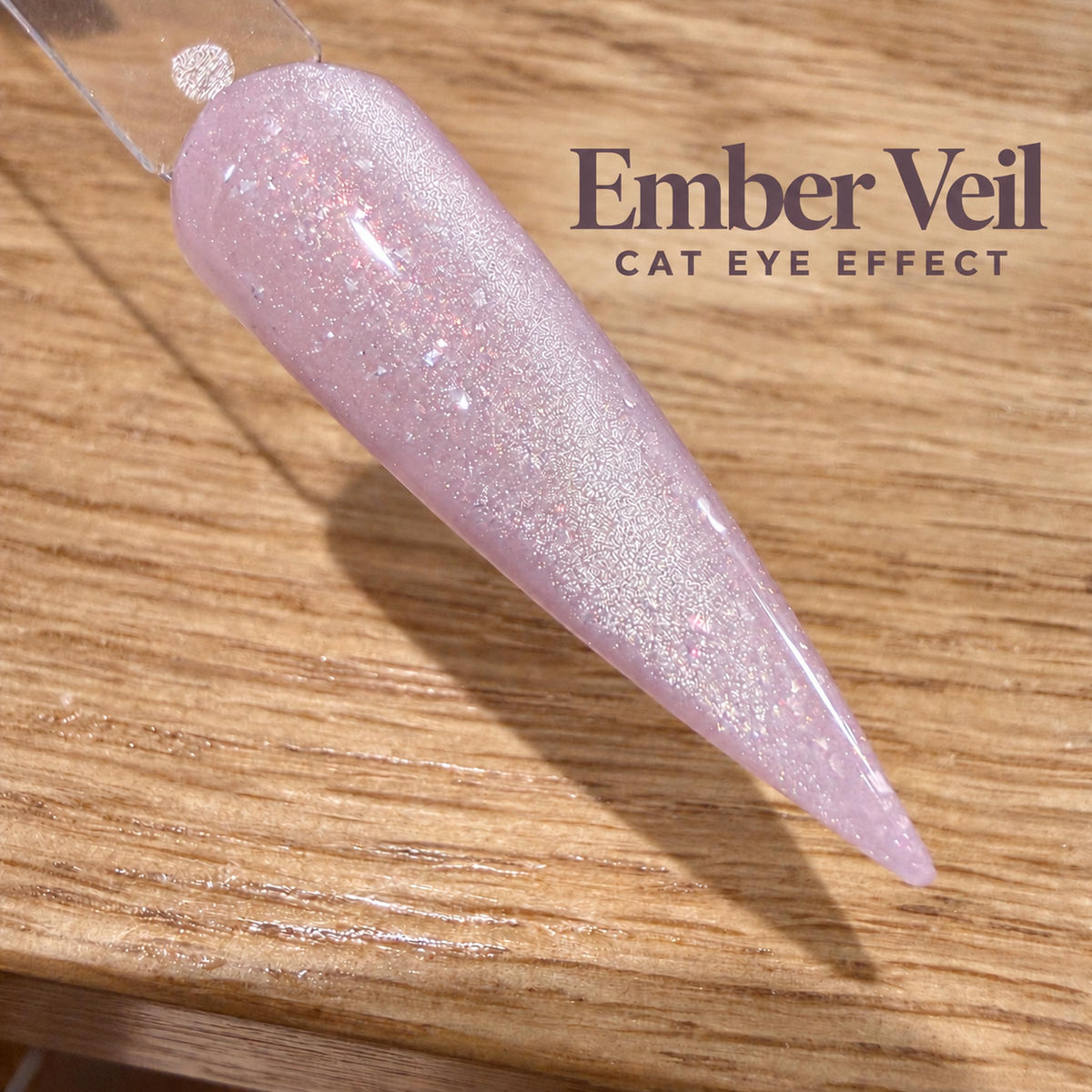 A close-up image of a glittery nail polish bottle on a wooden surface, with the text "Ember Veil CAT EYE EFFECT" displayed above it.