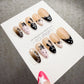 A collection of elaborately decorated nails with various star and bunny designs, displayed on a white background.