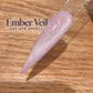 A close-up image of a purple glitter nail polish on a wooden surface, with the text "Ember Veil CAT EYE EFFECT" displayed above it.