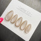 A set of five glittery nail polish bottles on a white card with text.